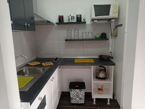 a small kitchen with a sink and a microwave at Buena Fuerte Apartamentos Mari Giuli in Tarajalejo