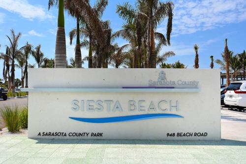 a sign for siesta beach with palm trees in the background at Canal 313 - Right in Siesta Key Village! in Siesta Key