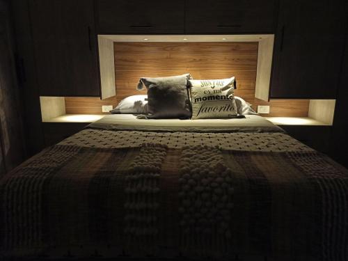 a bedroom with a large bed with a wooden headboard at Glamping Cabañas Sharmont in Guarne