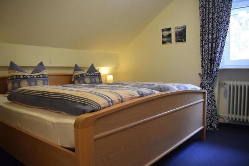 ein Schlafzimmer mit einem großen Bett mit blauen Kissen in der Unterkunft Apartment in Haidm hle with balcony or terrace in Haidmühle