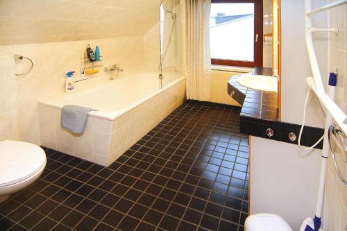 a bathroom with a tub and a toilet and a sink at Apartment, Beetzseeheide in Ketzür
