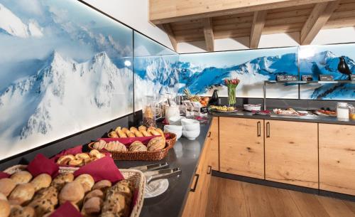 a breakfast room with mountains on the wall at Alpenhotel Schlüssel in Andermatt