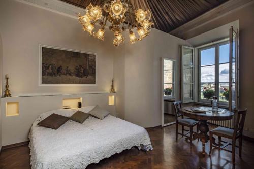 1 dormitorio con cama, mesa y lámpara de araña en La Dimora Dei Monaci en Siena