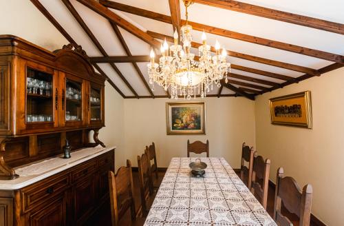 Azores Apartment في بونتا ديلغادا: غرفة طعام مع طاولة وثريا