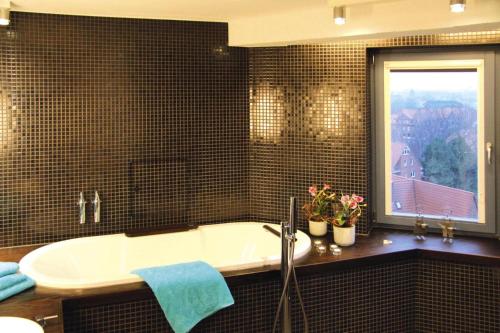 a bathroom with a bath tub and a window at Apartment in the water tower, Güstrow in Güstrow