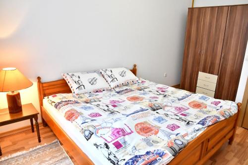 Una cama en un dormitorio con colcha. en Stan na dan Sunce en Lukavica