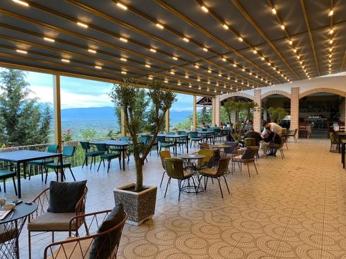 a restaurant with tables and chairs and people sitting at tables at Ardenica Boutique Hotel in Lushnjë