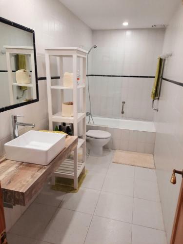 a bathroom with a sink and a toilet and a tub at Port Pollensa Pins 2 in Pollença