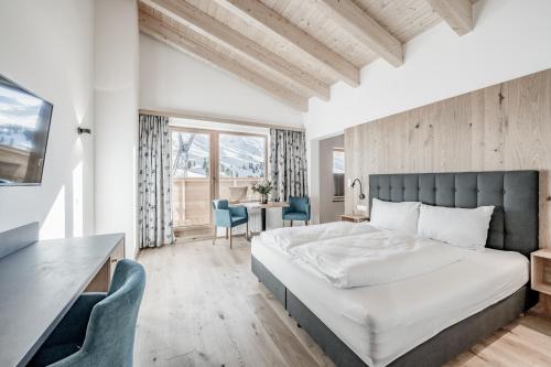 a bedroom with a bed and a table and chairs at Sporthotel Olymp in Hochgurgl