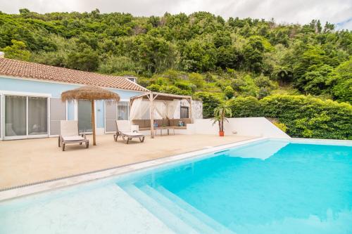a villa with a swimming pool and a gazebo at Casa do Outeiro with Heated Pool 30C in Povoação