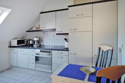 Apartment in Kleines Wiesental, Sallneck في Sallneck: مطبخ بدولاب بيضاء وطاولة زرقاء