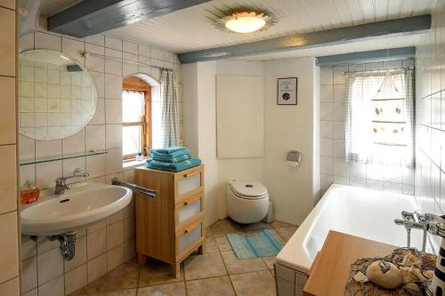 a bathroom with a sink and a tub and a toilet at Semi-detached house Posthus, Behrendorf in Behrendorf
