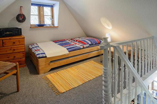 a small bedroom with a bed and a staircase at Semi-detached house Posthus, Behrendorf in Behrendorf