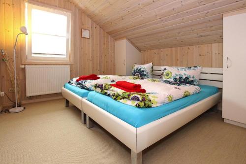 a bedroom with a large bed with a wooden ceiling at Ferienhaus mit Sauna am Dümmer See, Dümmer in Dümmer