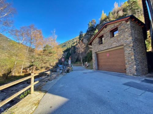 a garage with a wooden door on the side of a house at Casa amb molt encant i tranquilitat. in Ansalonga