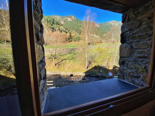 a window with a view of a mountain view at Casa amb molt encant i tranquilitat. in Ansalonga