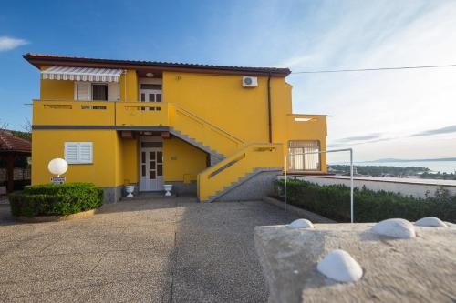 a yellow house with a yellow staircase in front of it at The Manzoni family 5 in Punat