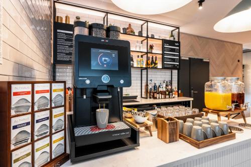 a coffee shop with a drink dispenser on a counter at Staycity Aparthotels Frankfurt Airport in Frankfurt/Main