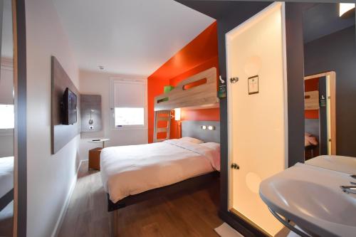 a bedroom with a bunk bed and a sink at ibis budget Saint Lô in Saint Lo