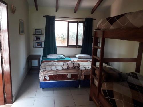 a bedroom with two bunk beds and a window at Hostel Serena in Samaipata