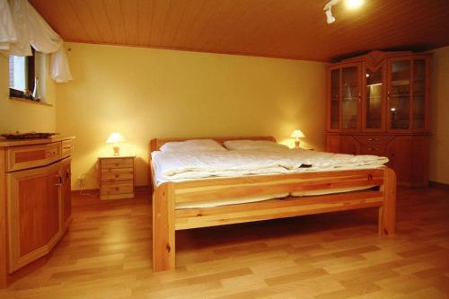 a bedroom with a bed and a cabinet and two lamps at Cottage, Dolgen am See in Klein Sprenz