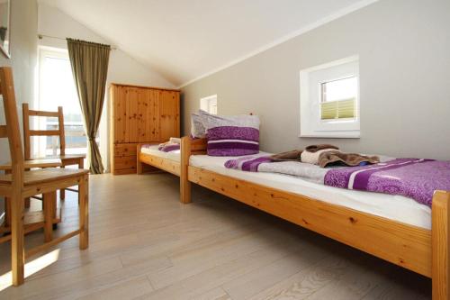 a bedroom with two beds and a dog laying on the bed at Holiday home An de Linn, Nakenstorf in Nakensdorf