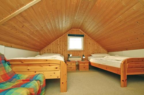 a bedroom with two beds in a wooden cabin at Holiday house at the Useriner See, Userin in Userin