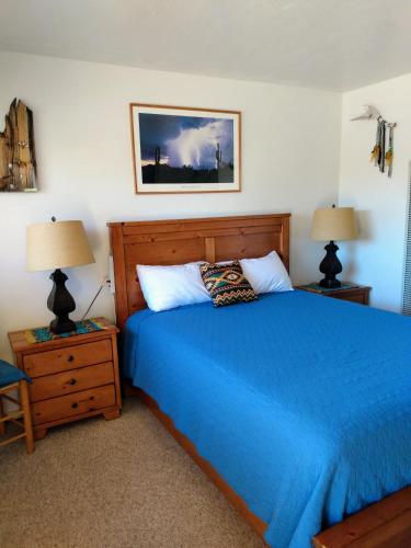 a bedroom with a blue bed and two night stands at Mokee Motel in Bluff