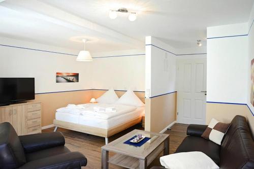ein Wohnzimmer mit einem Bett und einem Sofa in der Unterkunft Apartments home Wyk auf Föhr - DNS10067-SYA in Wyk auf Föhr