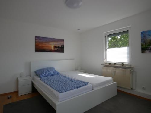 un dormitorio con una cama y una ventana en Neu ab 2022: Schöne Ferienwohnung in Top-Lage 84m2, en Langenargen