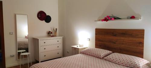 a bedroom with a bed and a dresser and a mirror at Hypnos Sleep and Go in Benevento