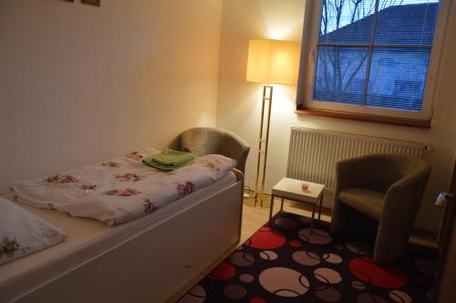 sypialnia z łóżkiem, krzesłem i oknem w obiekcie Bohemica Apartman 3 w mieście Kouřim