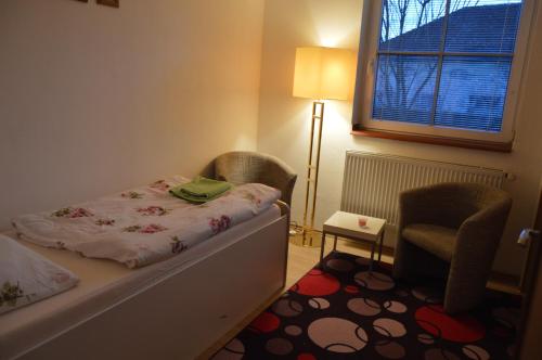 una camera da letto con un letto, una sedia e una finestra di Bohemica Apartman 3 a Kouřim