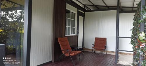 due sedie sedute sul portico di una casa di Hotel & Golf Isak Aeropuerto a Rionegro