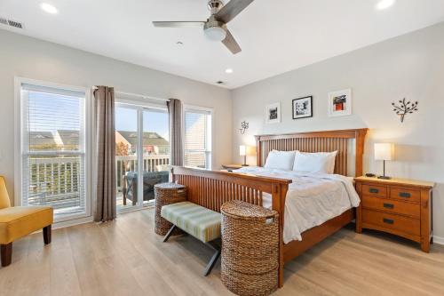 Un dormitorio con una cama y una silla y ventanas. en 113 Waters Edge Community, en Folly Beach