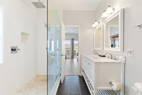 Un baño blanco con ducha y lavabo. en 113 Waters Edge Community, en Folly Beach