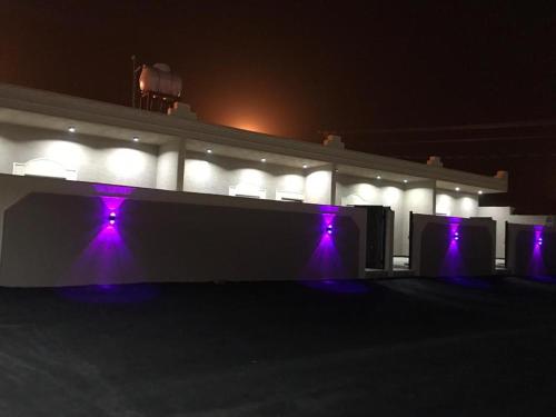 a building with purple lights on it at night at مجمع الضيف السكني in Khamis Mushayt