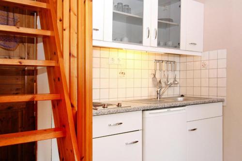 a kitchen with white cabinets and a sink at Holiday home in Markgrafenheide with paid sauna in Markgrafenheide