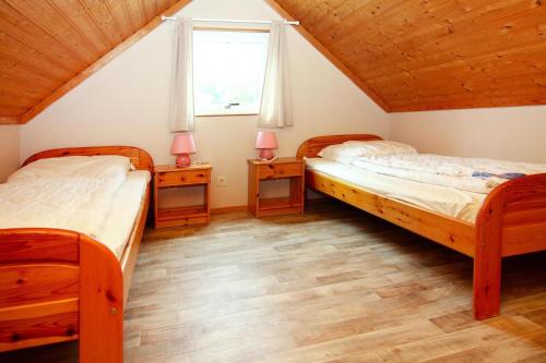 a bedroom with two beds and two night stands at Holiday home in Markgrafenheide with paid sauna in Markgrafenheide