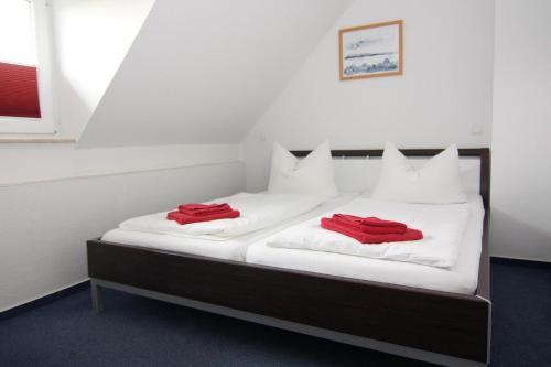 twee bedden in een kamer met rode handdoeken erop bij Semi-detached house, Kuehlungsborn in Kühlungsborn