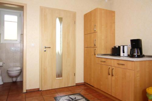 a bathroom with a toilet and a wooden cabinet at Doppelhaushälfte, Kühlungsborn in Kühlungsborn