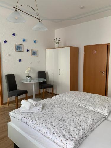 Schlafzimmer mit einem Bett und einem Tisch mit Stühlen in der Unterkunft Nathalie Leser in Baden-Baden