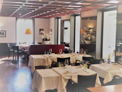 a dining room with tables and chairs with white table cloth at Hotel Schwanen Wil in Wil