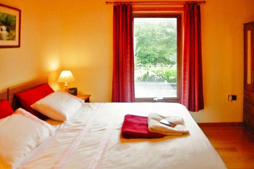 a bedroom with a large white bed with a window at Cottage, Manorhamilton in Manorhamilton