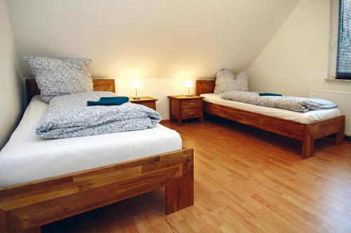 two beds in a room with wooden floors at Holiday home Kiebitz, Plau am See in Plau am See