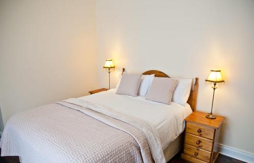 a bedroom with a white bed and two lamps at The Kerryway in Flesk Bridge