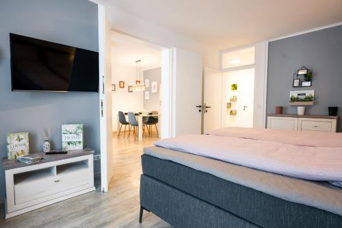 a bedroom with a bed and a table with a television at BoRa Apartments in Villach