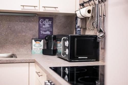 a kitchen counter with a microwave and a coffee maker at BoRa Apartments in Villach