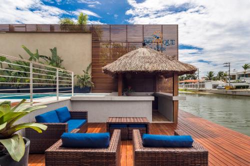 a deck with chairs and a gazebo next to the water at Pousada Boutique do lazer in Cabo Frio