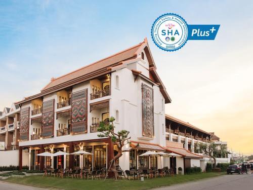 ein Hotel mit Tischen und Stühlen vor einem Gebäude in der Unterkunft T Heritage Hotel in Chiang Mai